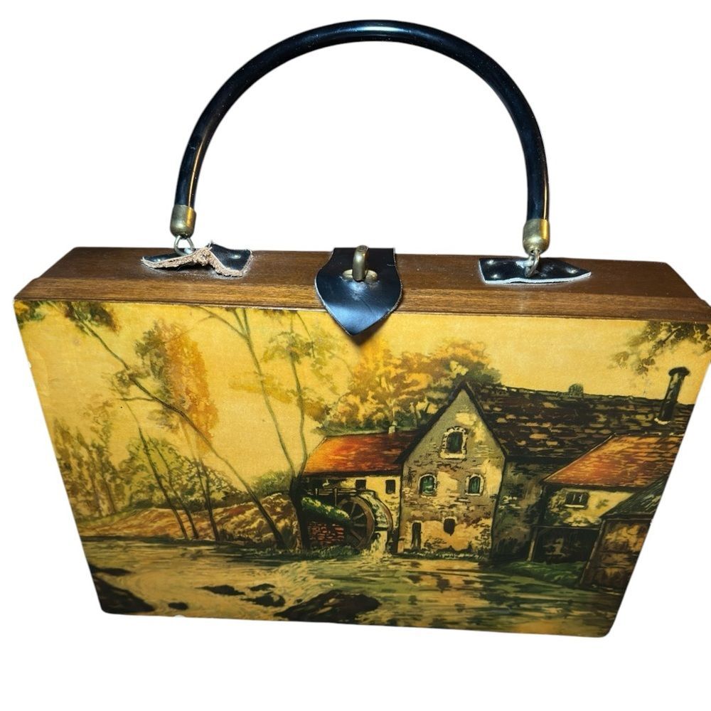 Vintage box purse with a country motif outside with a  a rural landscape.